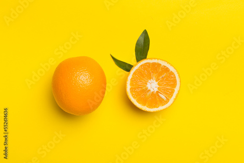 Flat lay with fresh oranges and leaves on color background