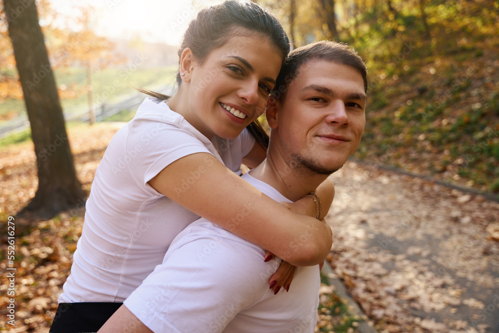 Fototapeta premium Strong guy rides his girlfriend on backs
