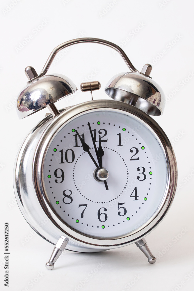 Metallic alarm clock with shadow on gray background Metallic alarm clock with shadow on gray background