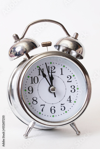 Metallic alarm clock with shadow on gray background