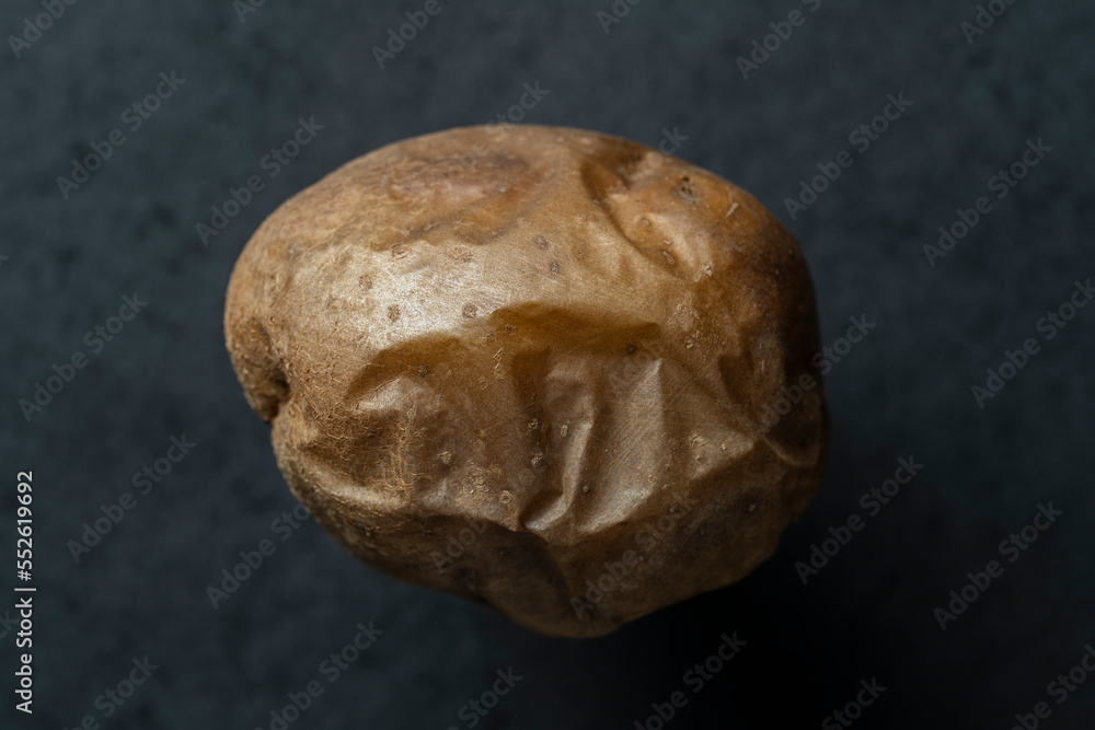 One baked potato on black background, closeup, top view One baked potato on black background, closeup, top view