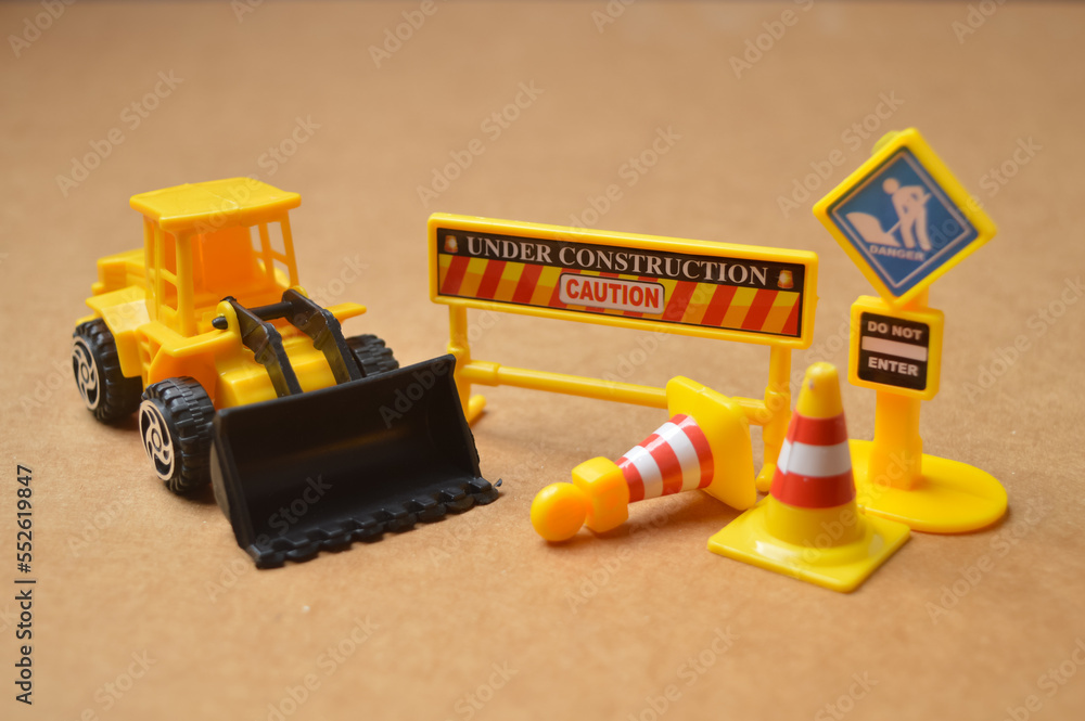 Obraz premium Under construction and Do Not Enter warning signs with yellow backhoe.