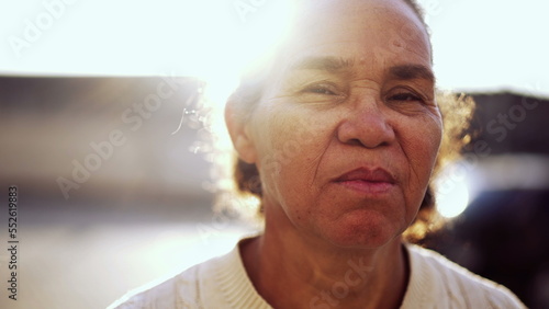 South American senior woman portrait face closeup standing outside with serious expression. Older female person looking at camera. Brazilian mature person