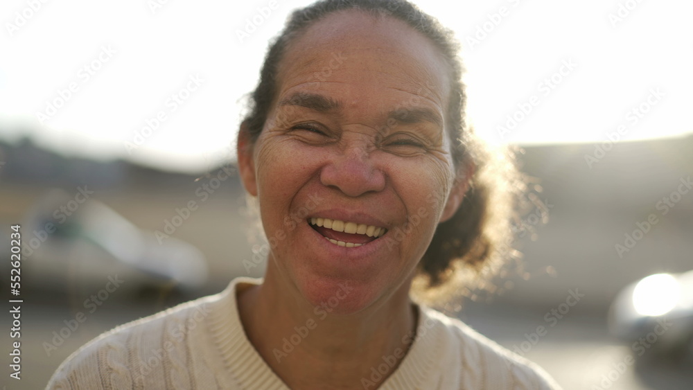 Joyful hispanic older woman portrait face smiling and laughing. Happy natural casual South American senior lady standing outdoors Joyful hispanic older woman portrait face smiling and laughing. Happy natural casual South American senior lady standing outdoors