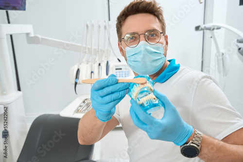 Stomatologist showing proper tooth-brushing technique before camera