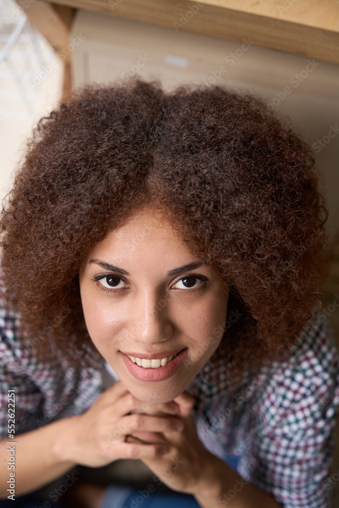 Smiling young curly woman looking into camera Smiling young curly woman looking into camera