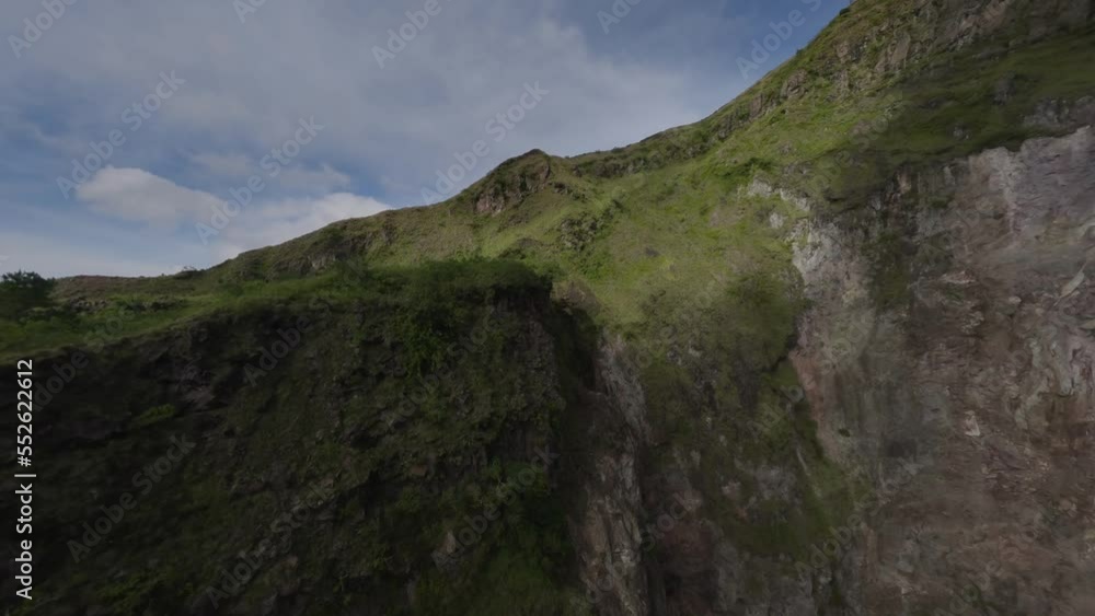 Volcano mountain ridge with fog raising up surrounded by exotic greenery valley altitude natural aerial view. FPV sports drone dive close low shot volcanic cliff canyon exotic island summit travel 4k Volcano mountain ridge with fog raising up surrounded by exotic greenery valley altitude natural aerial view. FPV sports drone dive close low shot volcanic cliff canyon exotic island summit travel 4k