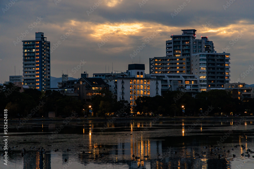 Apartment buildings with lights with sunset afterglow in clouds