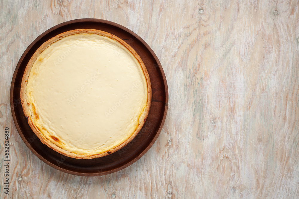 Cheesecake New York on a plate on a wooden background. Top view. Copy space Cheesecake New York on a plate on a wooden background. Top view. Copy space