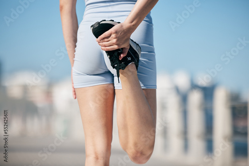 Woman, stretching legs and back view in city, street or urban road outdoor. Fitness, health and female athlete stretch or warm up before exercise, running or training outside for marathon run in town