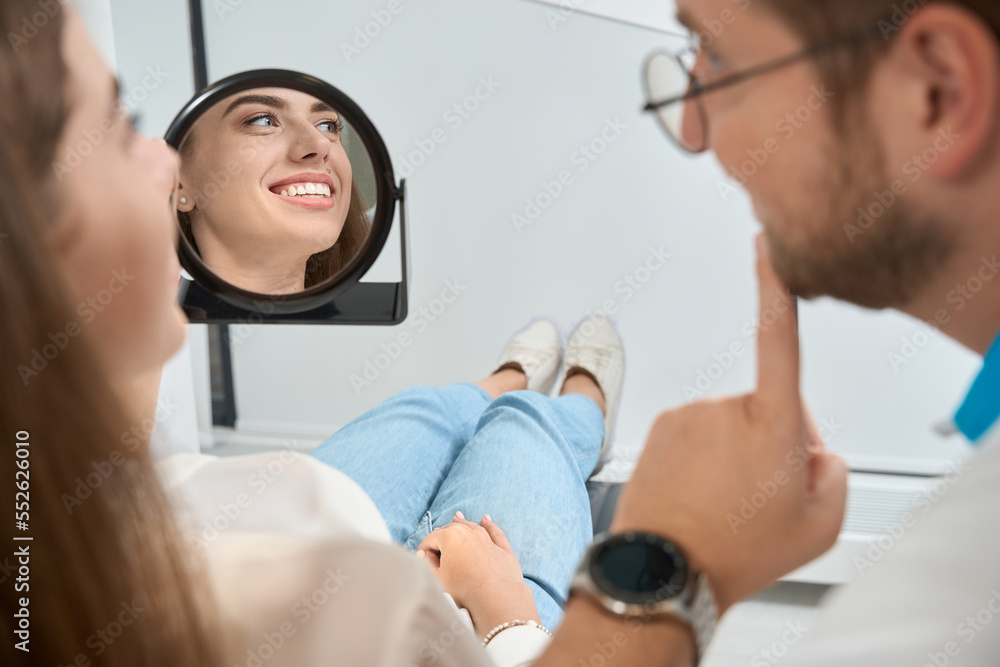 Grateful female patient smiling at dentist after treatment Grateful female patient smiling at dentist after treatment