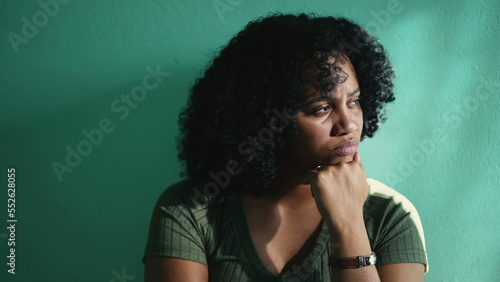 A concerned African American young woman. A pensive hispanic latin girl thinking in doubt