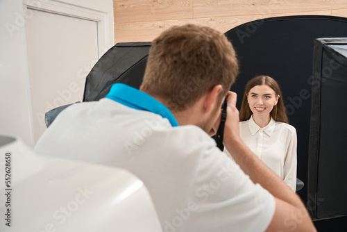 Dental hygienist photographing smiling client after teeth whitening