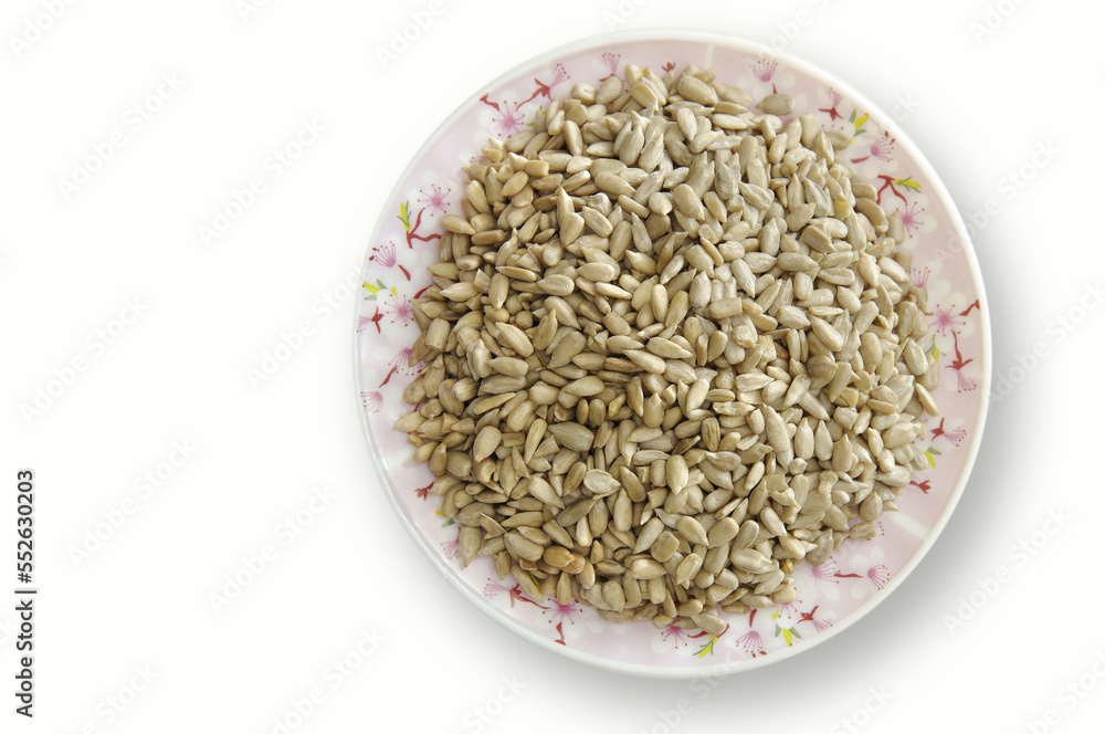 Peeled sunflower seeds in a plate on a white background. ecological seeds. Selective focus with copy space.
