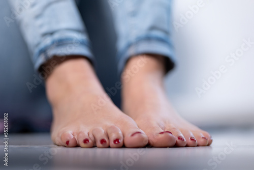 Sexy woman feet with red nail polish and a blue jeans