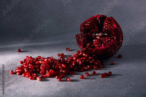 Fotografie Seeds of ripe red pomegranate are abundantly poured out of the fruit