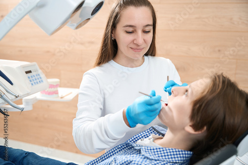 Child is sits in the dentist chair photo