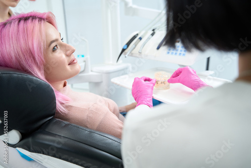 Cute woman with pink hair gets an orthodontist consultation