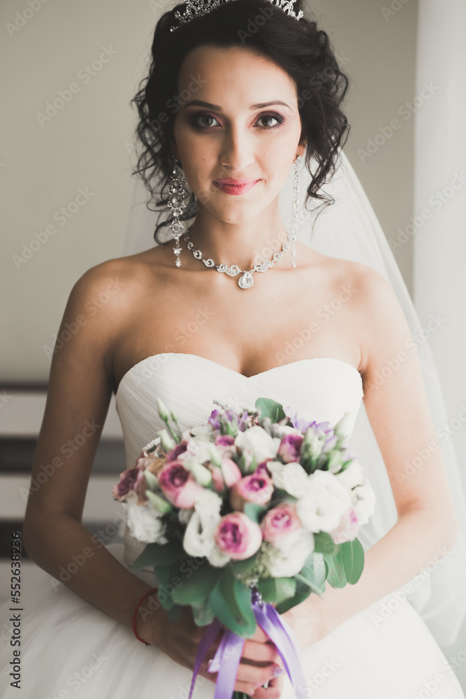 Naklejka premium Portrait of beautiful bride with fashion veil at wedding morning