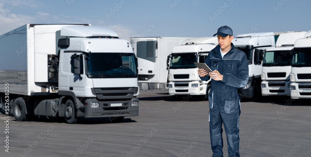 Manager with a digital tablet next to trucks. Fleet management Manager with a digital tablet next to trucks. Fleet management