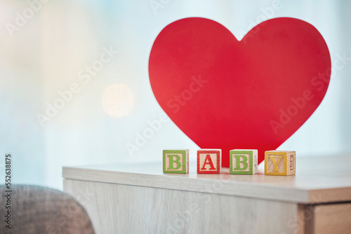 Heart, sign and baby toy announcement for a kid, child or newborn on a family home table. Love, care and announce or notification in wooden building blocks design for colourful news with a shape photo