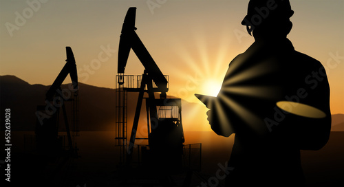 Foto Silhouette of engineer with a digital tablet on the background of oil rigs