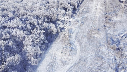 High-voltage power lines through the winter forest.	