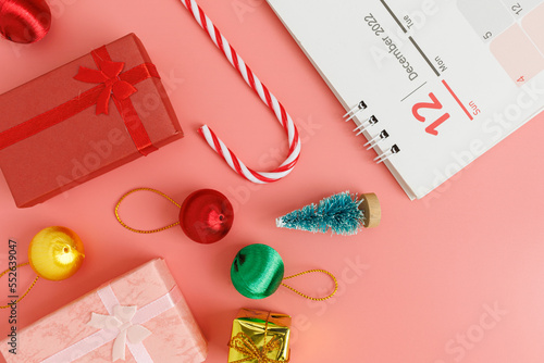 Christmas composition decoration. Gifts, Christmas tree, snowflake, Christmas ball, Santa's cane, and December 2022 calendar on red background. Christmas, winter, new year concept. Flat lay, top view.