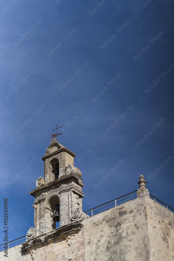 Parte superior de fachada de iglesia antigua con cielo azul de fondo 
