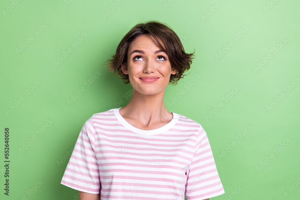 Photo of optimistic bob hairdo millennial lady look up wear white striped t-shirt isolated on green color background Photo of optimistic bob hairdo millennial lady look up wear white striped t-shirt isolated on green color background