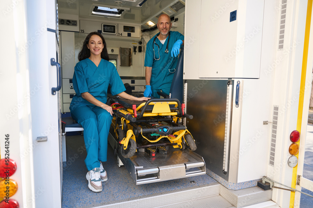 Man and woman in medical uniforms are inside an ambulance Man and woman in medical uniforms are inside an ambulance
