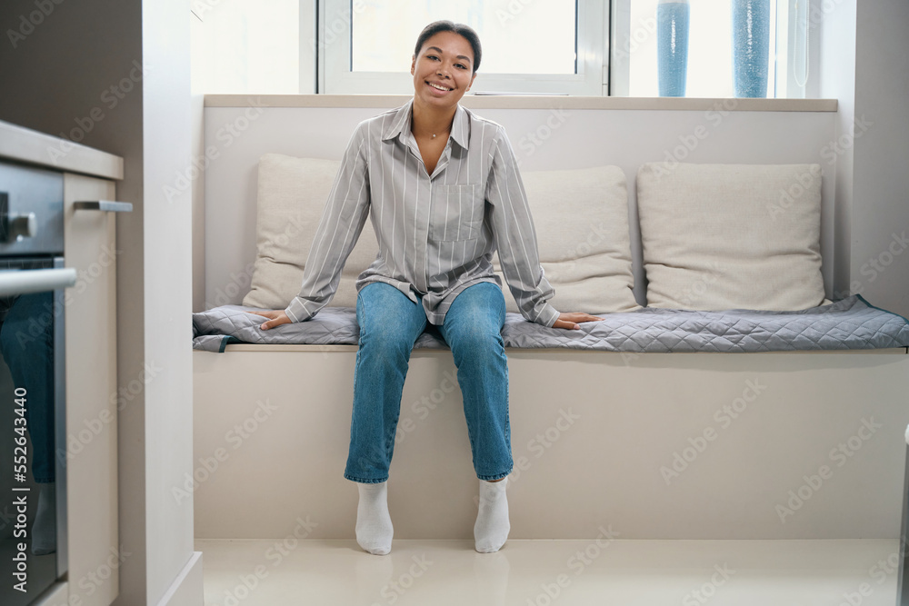 Smiling cheerful woman is casual clothes is spending time at home Smiling cheerful woman is casual clothes is spending time at home