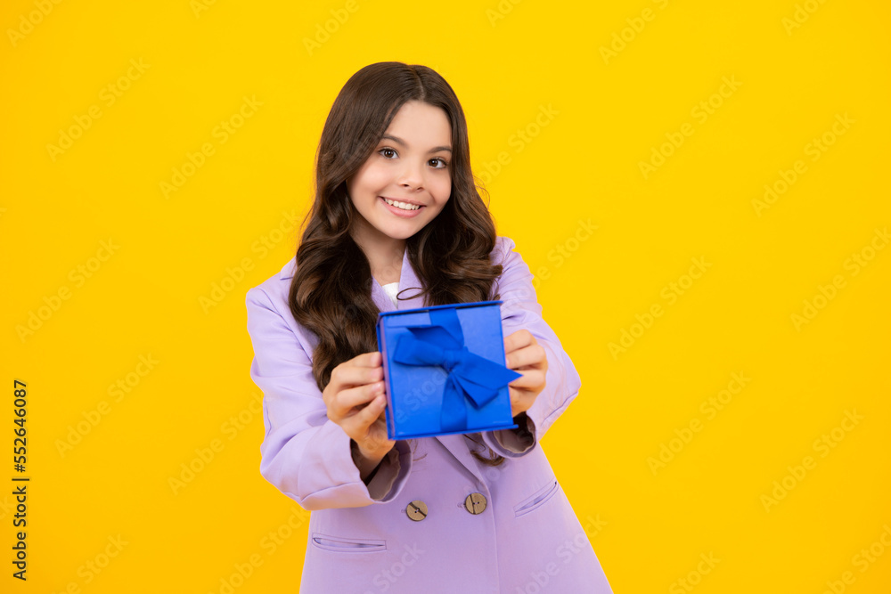 Happy teenage girl. Teenager child holding gift box on isolated yellow background. Gift for kids birthday. Christmas or New Year present box. Smiling kids emotions. Happy teenage girl. Teenager child holding gift box on isolated yellow background. Gift for kids birthday. Christmas or New Year present box. Smiling kids emotions.