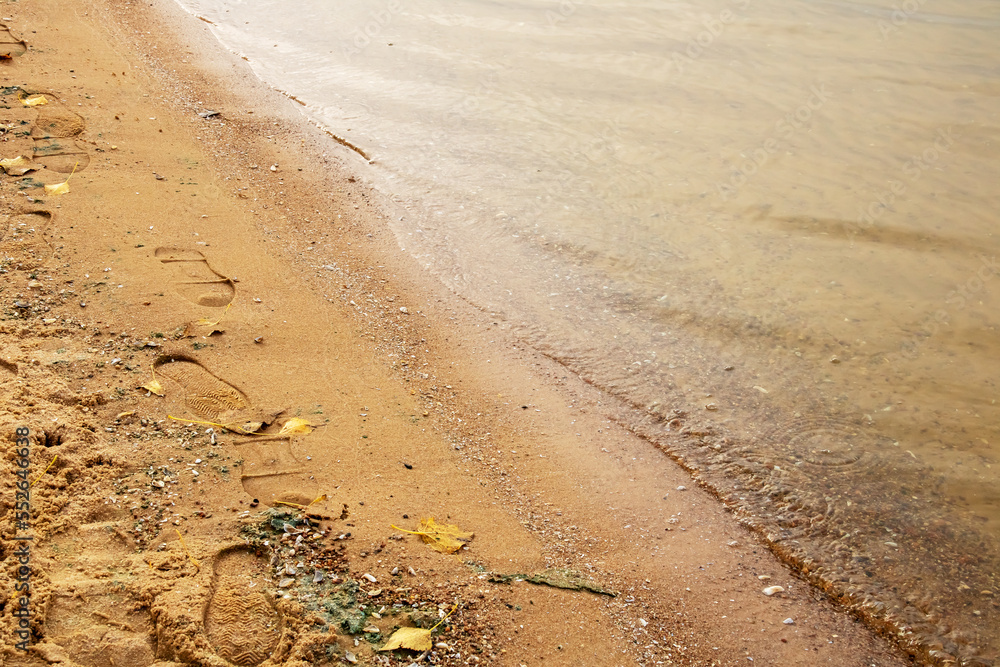 Human footprints on the sand near the water Human footprints on the sand near the water