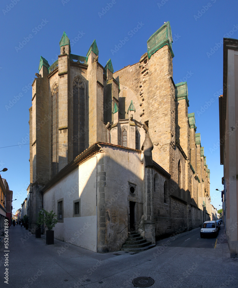 Decaying gothic church of St Vincent with buttress constructions and fall protection nets in the old city of Carcassonne, France