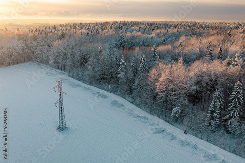 View with snowy treetops, power lines and hiking path from above in Espoo, Finland