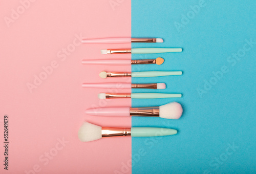 Cosmetic brush for makeup on a pink-blue background. Cosmetic product for make-up. Creative and beauty fashion concept. Fashion. Collection of cosmetic makeup brushes, top view, banner.Place for text.