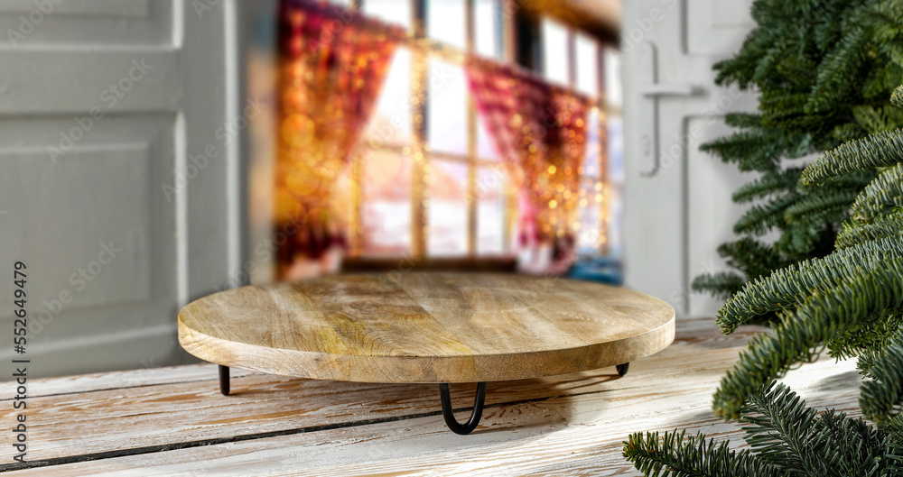 Wooden table in Christmas interior, open door to cityscape with defocused lights, free space