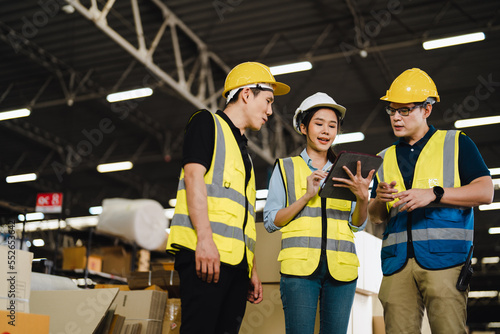 Group of Asian industrial worker has meeting to brainstorm and discuss at warehouse factory workplace. Industrial worker has planning and discussing scene. Auditor working onsite.