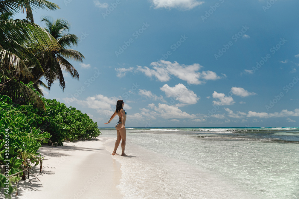 Obraz premium Young beautiful European female fit tanned model walking at exotic Saona island in Dominican Republic