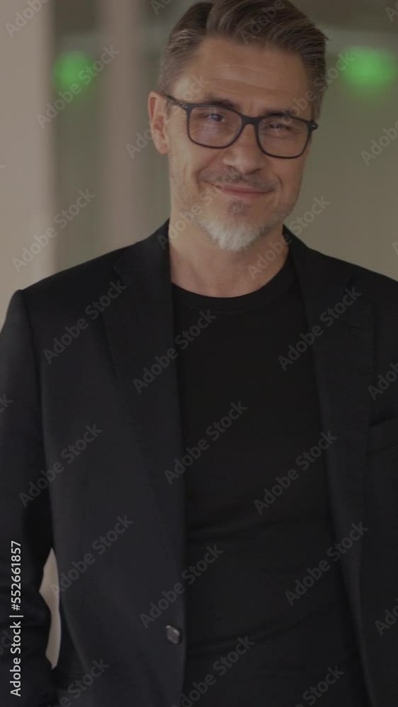 Business portrait - businessman standing on office corridor. Happy middle aged, mid adult, mature age man smiling. Entrepreneur in modern workplace. Copy space.