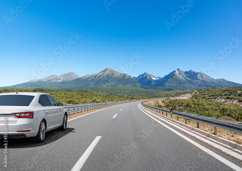 Picturesque road in the mountains and a white car. © Denis Rozhnovsky