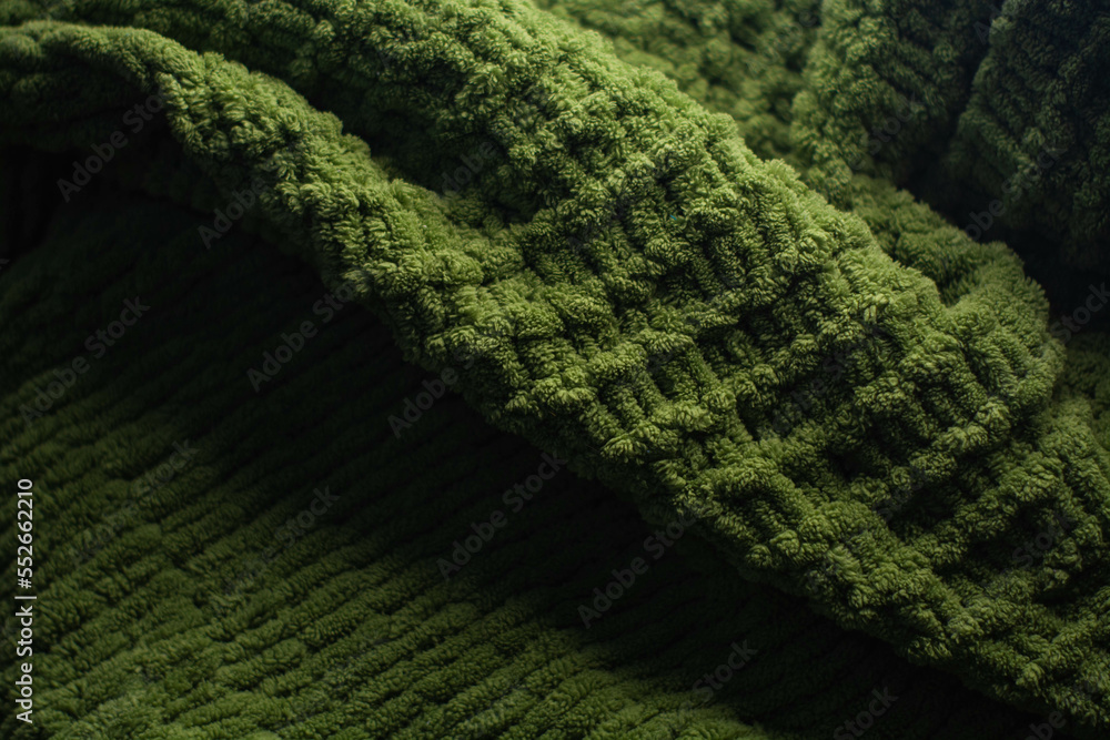 Monochrome background of cozy green knitted sweater