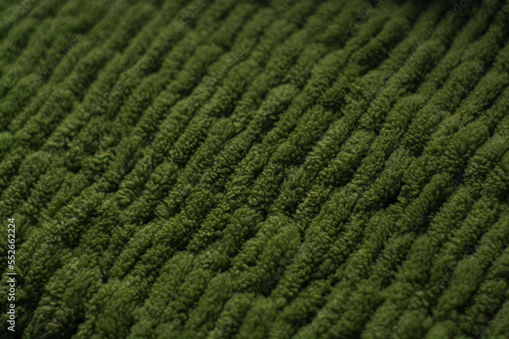 Monochrome background of cozy green knitted sweater