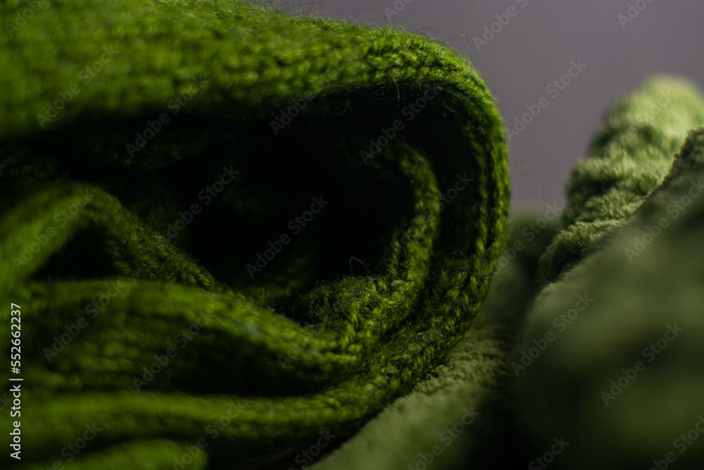Monochrome background of cozy green knitted sweater