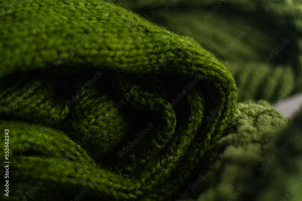 Monochrome background of cozy green knitted sweater