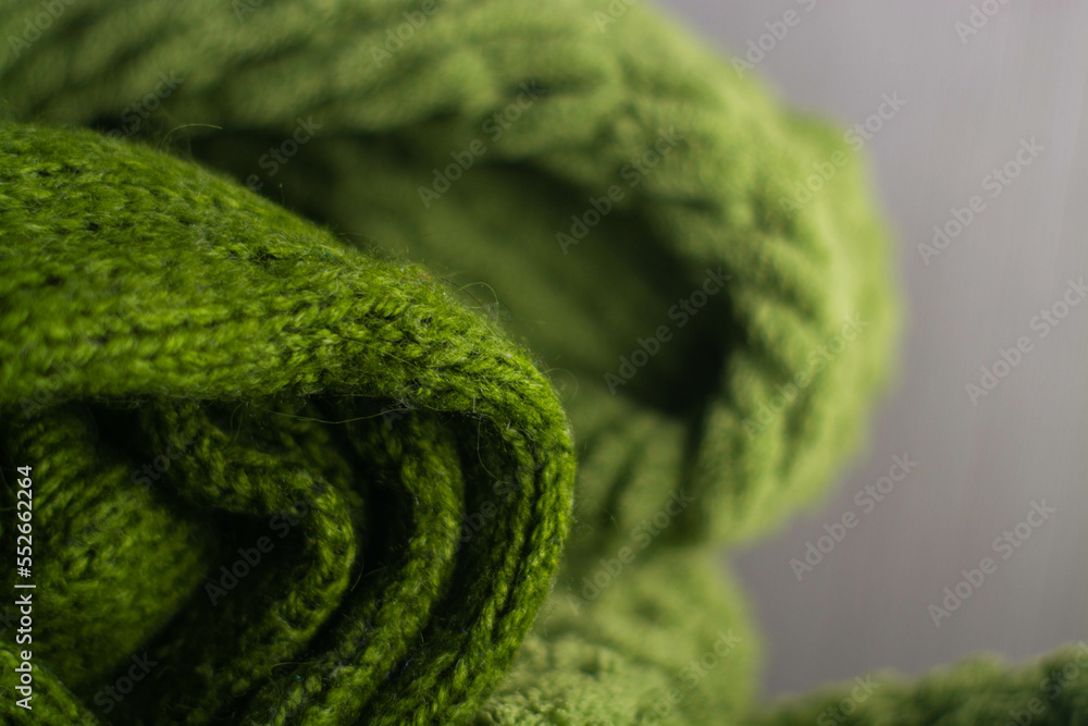 Monochrome background of cozy green knitted sweater