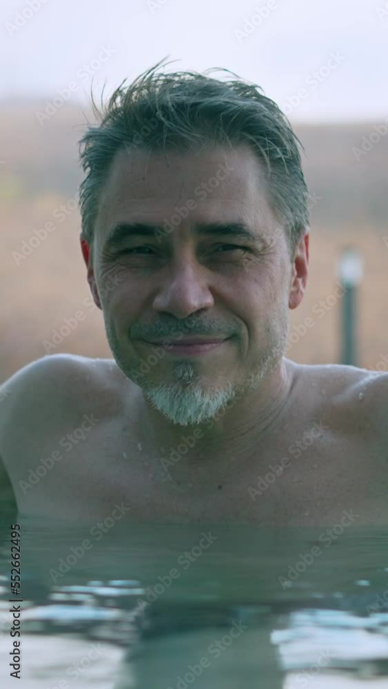 Man enjoying hot thermal water in cold weather. Relaxing bath in outdoor whirl pool in wellness spa, real authentic moment. Happy mid adult, middle aged guy smiling. Man enjoying hot thermal water in cold weather. Relaxing bath in outdoor whirl pool in wellness spa, real authentic moment. Happy mid adult, middle aged guy smiling.