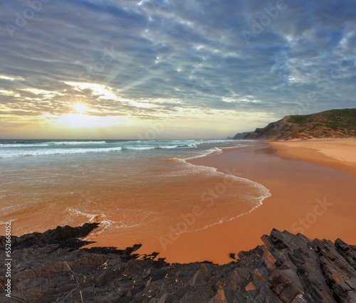 Storm on Castelejo beach with black schist cliffs (Algarve, Portugal). Peoples unrecognizable.