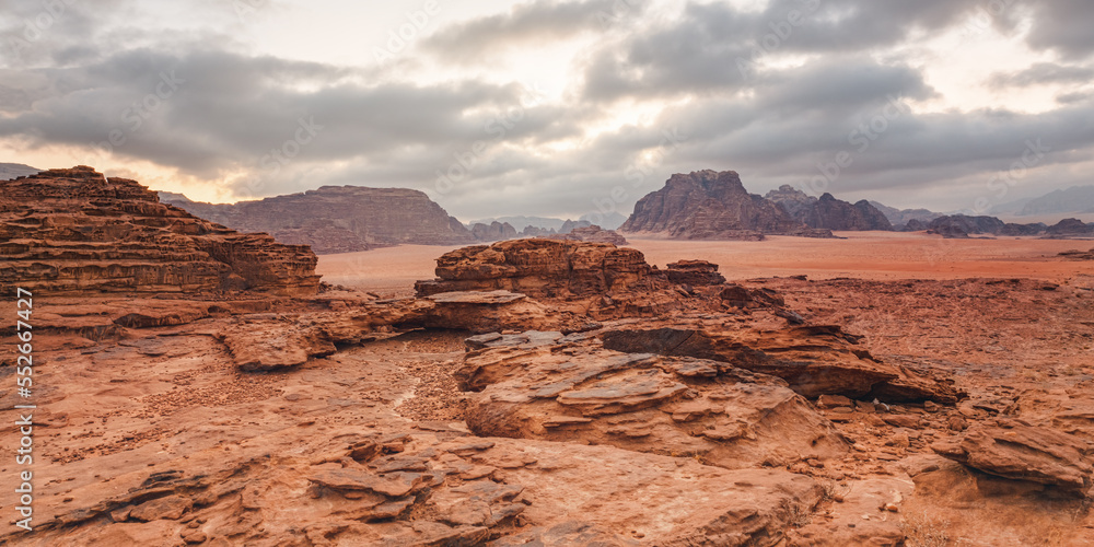 Red orange Mars like landscape in Jordan Wadi Rum desert, mountains background, overcast morning. This location was used as set for many science fiction movies Red orange Mars like landscape in Jordan Wadi Rum desert, mountains background, overcast morning. This location was used as set for many science fiction movies